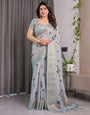 Elegant Ice Grey Handloom Linen Saree with Floral Print, Gold Zari Border & Tassel Detailing | Attached Blouse Piece | 5.5m Saree + 0.8m Blouse
